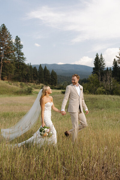 couple standing on shore of a lake in glacier kissing