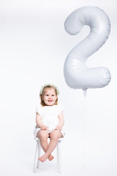 Vrolijke cakesmash fotoshoot voor de eerste verjaardag, met kleurrijke taart en feestelijke setting bij Studio 2Shoot in Eijsden.

