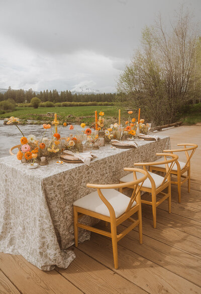 An elegantly set wedding table rests atop a bridge, blending natural beauty with thoughtful design—an unforgettable setting suspended between romance and adventure.