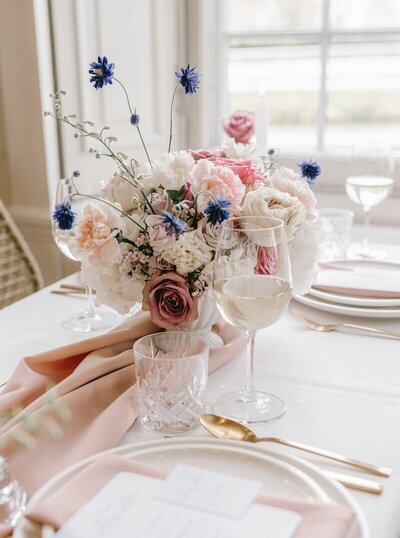 Tafelstuk diner bruiloft bloemen weelderige vorm, roze, paars en wit
