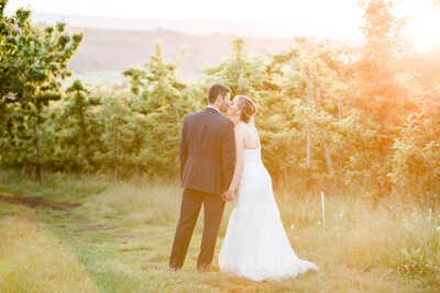 bride and groom standing in grass in the pacific Northwest.