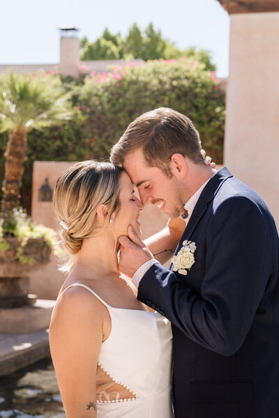 Bride and groom smiling as groom holds bride's chin at the Royal Palms Resort wedding venue in Scottsdale, Arizona.