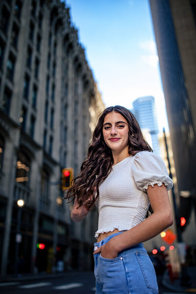 Stylish senior portrait in downtown Pittsburgh featuring young woman in white top against urban architecture.