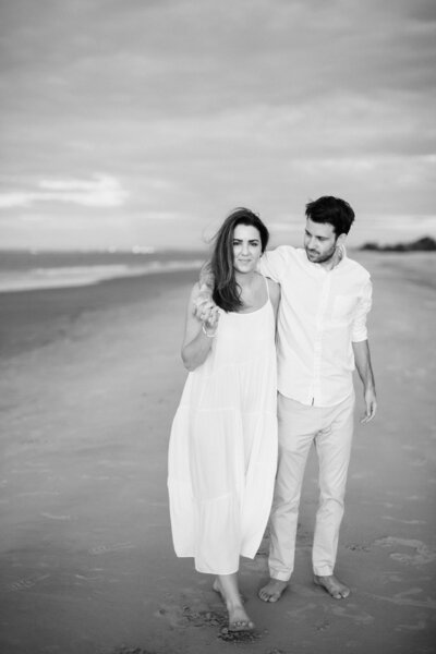 couple walking on beach in engagement photos