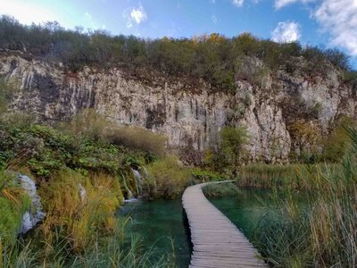 Wooden boardwalk winding over emerald-green water, surrounded by waterfalls and limestone cliffs in Plitvice Lakes National Park, Croatia ©Stephanie Dosch | theViatrix Luxury Travel