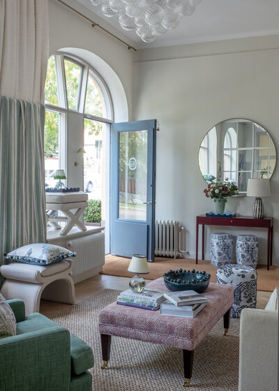 Närbild på designböcker, silverdetaljer och ranunkel – detaljer från Caspar & Co:s vardagsrumsstyling
