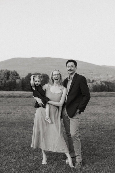 Jess and Corey Combs smiling holding their daughterin Manchester, Vermont