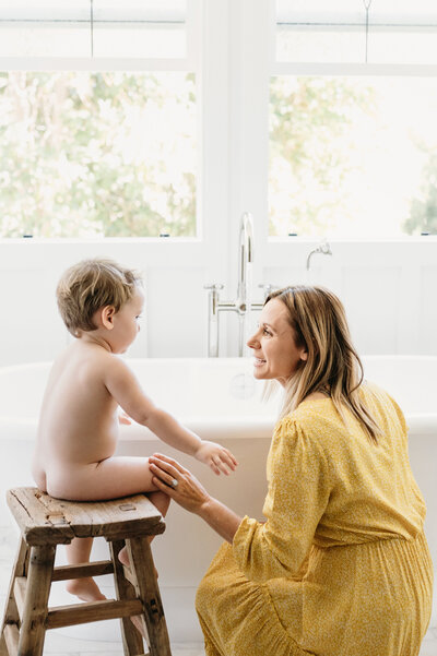 mom by bathtub with son
