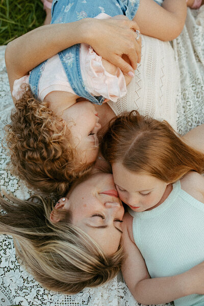 Mom holding her daughters during a family session at the park in Waterloo, Ontario.
