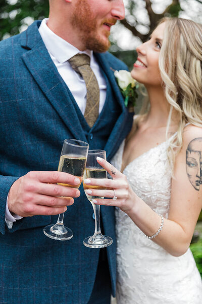 Bride and groom holding champagne glasses together