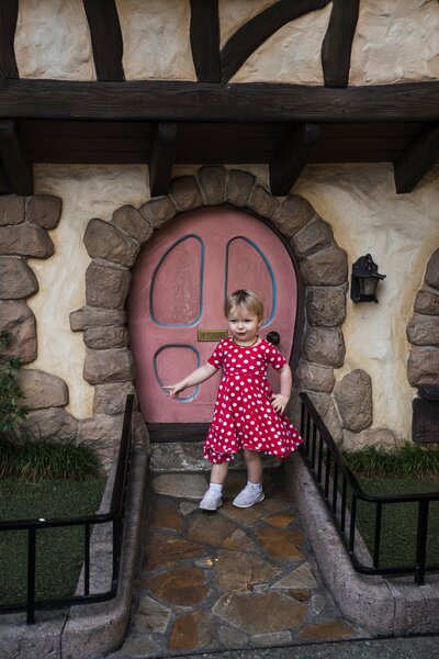 Toddler at Disneyland in Fantasyland in Minnie Mouse dress