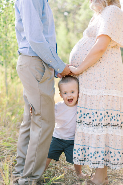 spokane wa maternity photography son looking through mom and dad hands