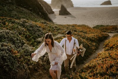 couple hikes up coastal trail on elopement