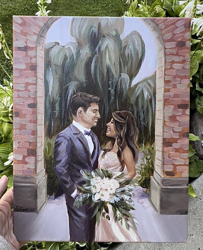 Painting of bride and groom with bouquet under arch