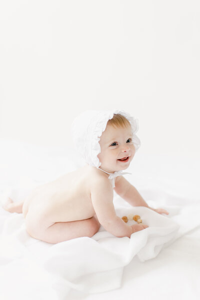 Light and airy six month old baby in bonnet