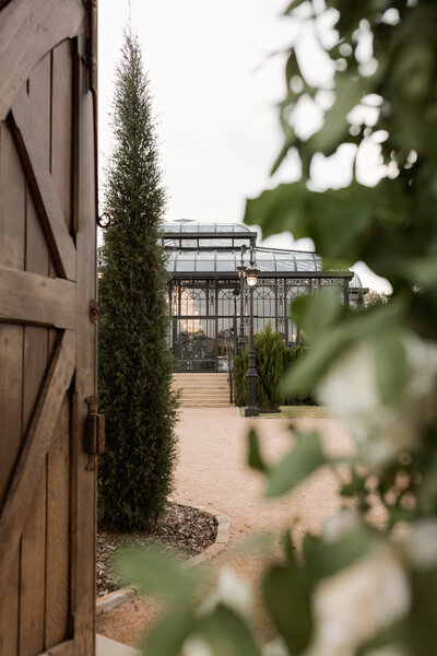 View of glass house from ceremony area at blackberry ridge wedding venue