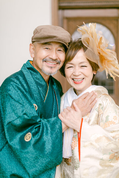 Older couple celebrating anniversary in Japanese kimono: woman in iro-uchikake (色打掛) and man in montsuki hakama.