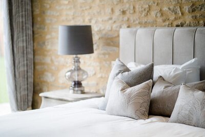 Elegant and cosy bedroom with cushions in Caswell House’s on-site wedding accommodation