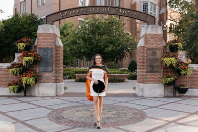 uf grad posing under university of florida sign