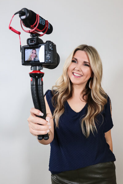 woman smiling holding a camera