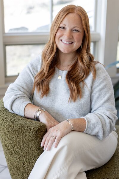 Katie Hopkins, owner, event planning and designer, sitting down and smiling at the camera.