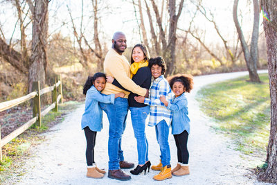 Family-of-five pose together in outdoor Fall photoshoot.