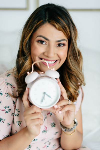 Prasha smiling with a clock
