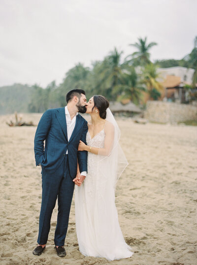 Couple kissing on the beach at Mexico Wedding