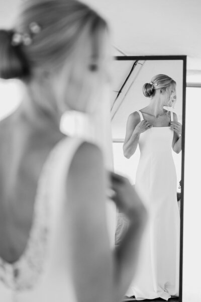 bride looking in the mirror at her wedding dress
