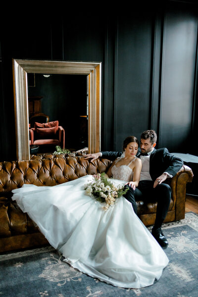 bride and groom sitting on a couch at the broadway avenue in grand rapids michigan lindsay elaine photography