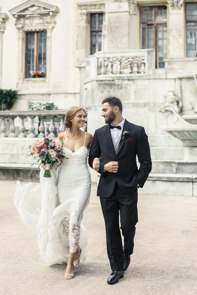 bride-and-groom-walking-outside-of-chateau