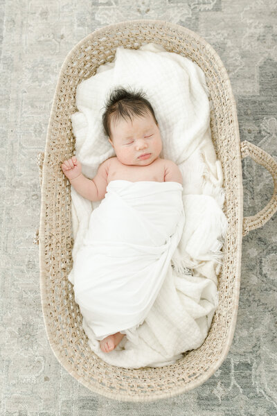 Sleeping newborn baby boy in a basket