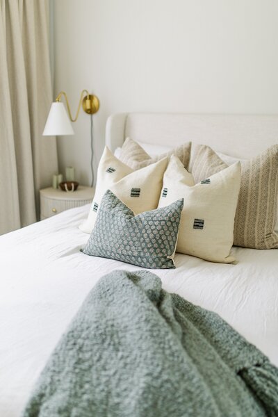 Bohemian woven basket accent chair with striped pillow and knitted blanket in Carlsbad, California.