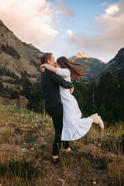 Couple poses in front of a misty mountain in Crested Butte , Colorado.