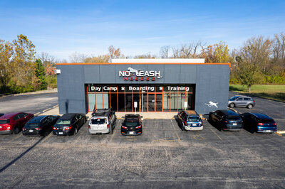 Aerial photography of the front of building that advertises dog boarding, training, and day camps.