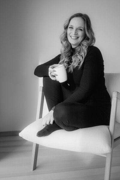 Ein lachendes Bild von mir, Karin, mit einer Kaffeetasse.