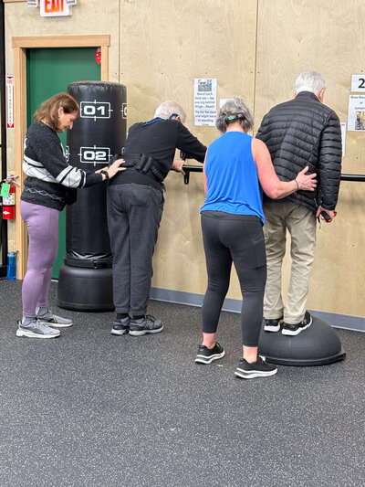 Coach Lori provides balance support during a Parkinson's exercise class at the Warriors gym. 