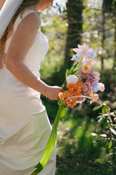 bride holding basket of flowers at sunny Texas wedding