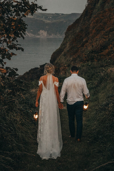 couple holding hands walk by the ocean