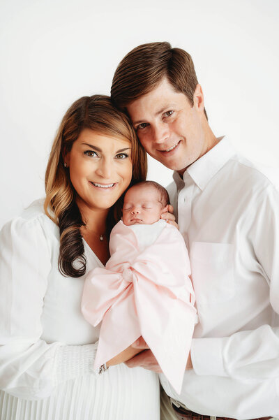 New parents embrace their infant during Newborn Portrait Session in Charleston, SC.