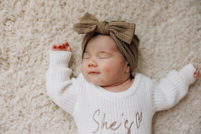newborn girl smiling during her in home newborn photo shoot with jennifer mosier photography