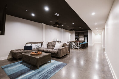 Lounge area with large couch, table, and barstools