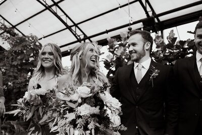 black and white photo of bride and groom with wedding party behind them