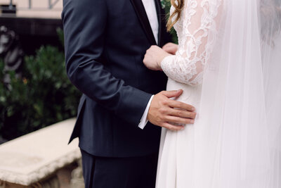 Close-up of the groom holding the bride’s waist in an intimate wedding moment, with no faces visible, during their Richmond, VA wedding.