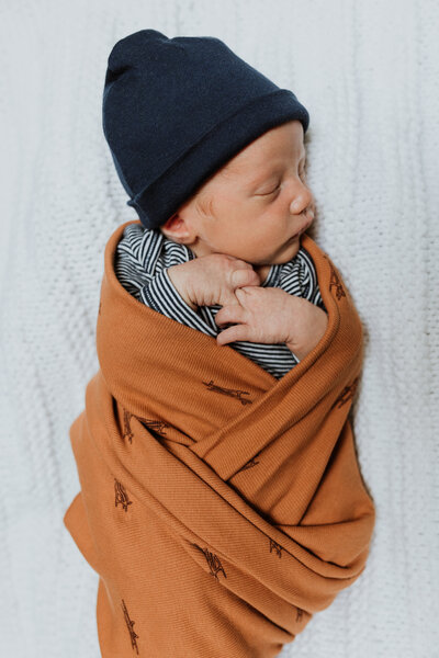 Newborn baby boy wrapped up and sleeping for his newborn phtoos.