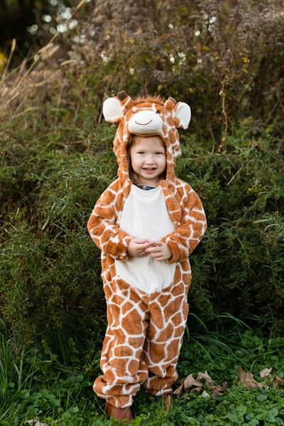 Little boy wearing giraffe costume and smiling