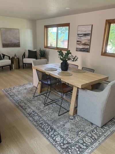 Cozy dining area featuring linen chairs, warm wood, and organic accents.