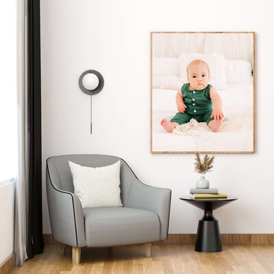 fraframed photo of little boy in green holding toes during Springfield Mo baby milestone sessionmed newborn photo in Springfield MO of living room