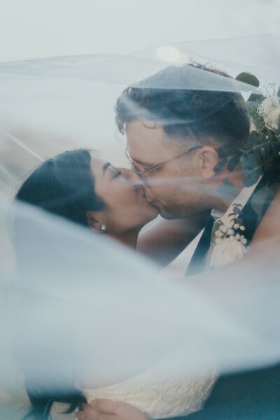 A diverse married couple sharing a kiss after their wedding in Los Angeles.