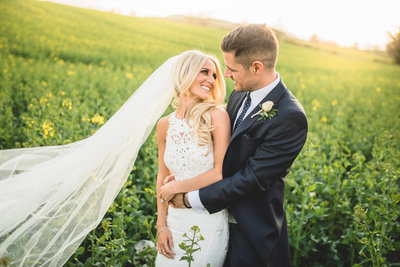 bride and groom in a field of rapeseed in yorkshire